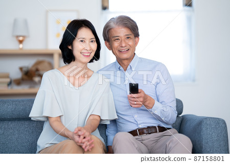 Senior couple watching TV with remote control 87158801