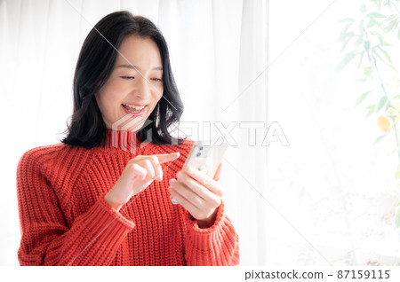有一個複制空間供美麗的亞洲（日本）女性在智能手機上尋找東西。 87159115