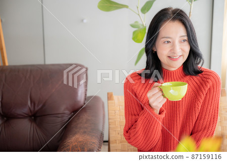 一位亞洲（日本）女性喝杯咖啡放鬆身心，前面有一個複印空間 87159116