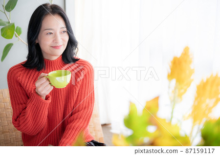 一位亞洲（日本）女性喝杯咖啡放鬆身心，前面有一個複印空間 87159117
