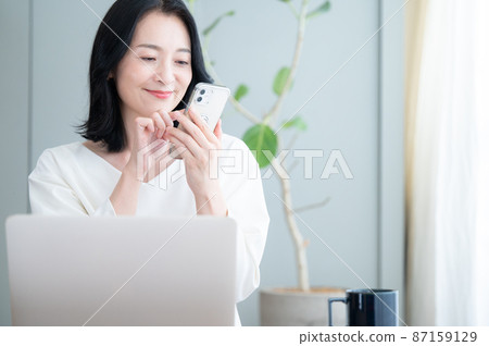 Tap on your smartphone to see a beautiful Japanese woman with a zoom copy space 87159129