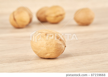 Walnuts on a wooden background, one nut in the foreground 87159668