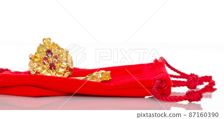 Yellow and orange sapphire Jewel or gems ring on red velvet bag. Collection of natural gemstones accessories. Studio shot 87160390