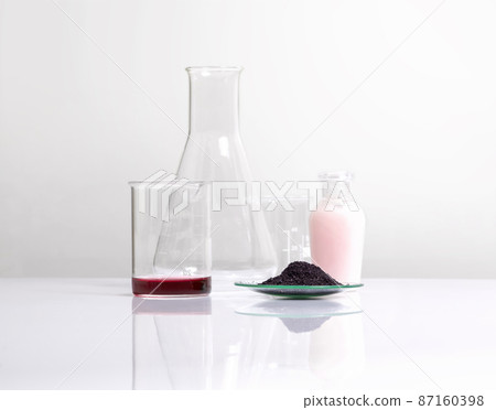 Cosmetic chemicals ingredient on white laboratory table. Potassium Permanganate Liquid, KMnO4, Beauty care cream place next to beaker and erlenmeyer flask. 87160398