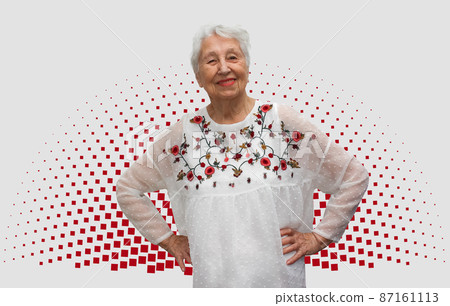 Old smiling woman with happy expression on her face on art studio background. Human emotions concept. Positive emotional old lady standing indoor 87161113