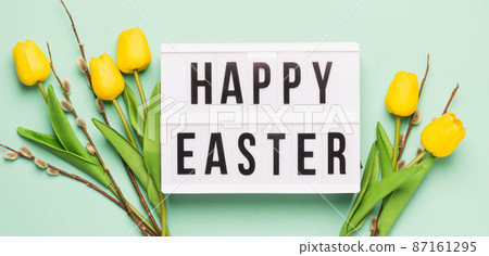 Festive spring composition yellow tulips twigs of fluffy willow and board with the text Happy Easter Festive spring composition yellow tulips twigs of fluffy willow and board with the text Happy Easter 87161295