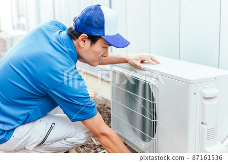 Air conditioner outdoor unit and men in work clothes 87161536