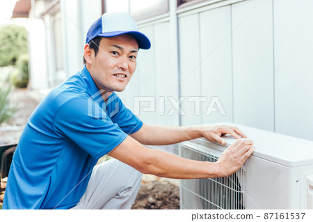 Air conditioner outdoor unit and men in work clothes 87161537