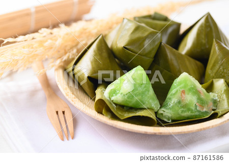 Thai dessert (Khanom Tian), Sweet dough pyramid stuffed with coconut wrapped by banana leaf 87161586