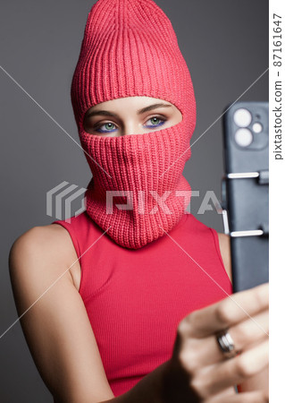 girl in balaclava taking pictures of herself. fashion blogger girl in balaclava taking pictures of herself. fashion blogger 87161647