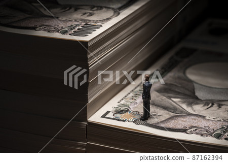 Money (a wad of bills) and a miniature businessman Money (a wad of bills) and a miniature businessman 87162394