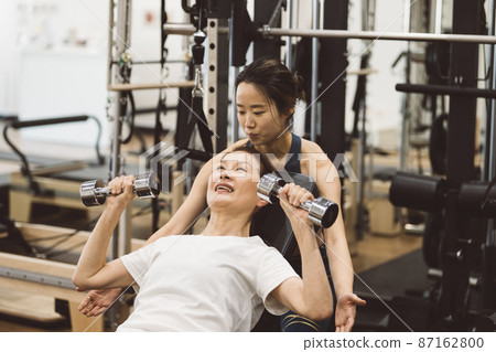 進行個人訓練的女性·在健身房進行肌肉訓練的女性 87162800