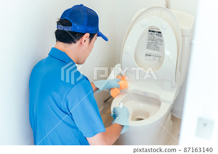一個穿著工作服的男人在打掃廁所 87163140