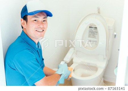 一個穿著工作服的男人在打掃廁所 87163141