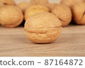 Walnuts on a wooden background, one nut in the foreground 87164872