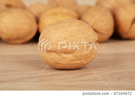 Walnuts on a wooden background, one nut in the foreground 87164872