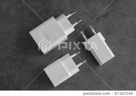Three phone or tablet chargers on dark background Three phone or tablet chargers on dark background 87167540
