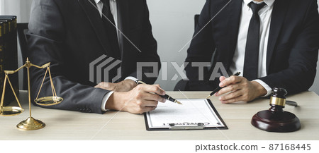 Male lawyers or a judge counseling clients about judicial justice and prosecution with scales, judges gavel, legal documents legal services concept 87168445