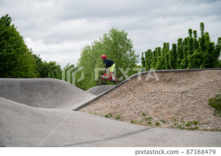 Boy riding a bike on a pump track Boy riding a bike on a pump track 87168479