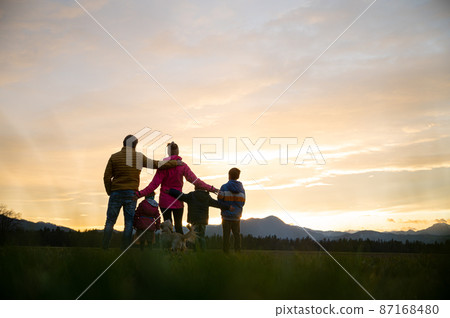 Family of five having fun outside at dusk 87168480