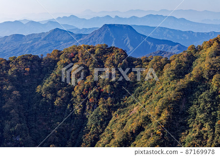 A distant view of Mt. Fuji and the Tenjin ridge of autumn colors seen from Mt. Tanigawa and Nishikuro ridge 87169978