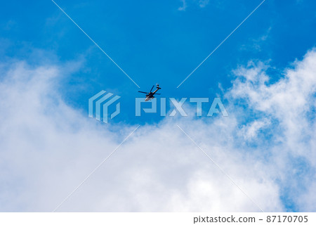 Italian Military Helicopter against a Clear Blue Sky with Clouds - Italy 87170705