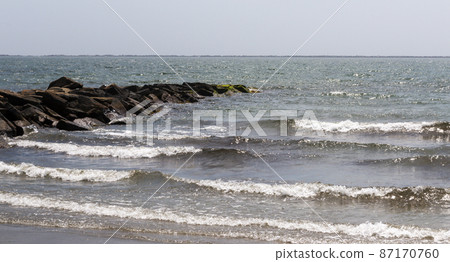 Waves next to rock jetty in Narragansett bay at Roger Wheeler State Beach Rhode Island 87170760