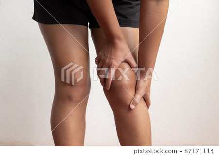 A woman supporting herself from numbness, muscle weakness, pain, and tingling in the knee nerve endings. This is a side effect of Guillain-Barre Syndrome after vaccination against COVID-19 A woman supporting herself from numbness, muscle weakness, pain, and tingling in the knee nerve endings. This is a side effect of Guillain-Barre Syndrome after vaccination against COVID-19 87171113