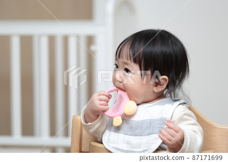 A 10-month-old baby playing with a toy that hardens his teeth 87171699
