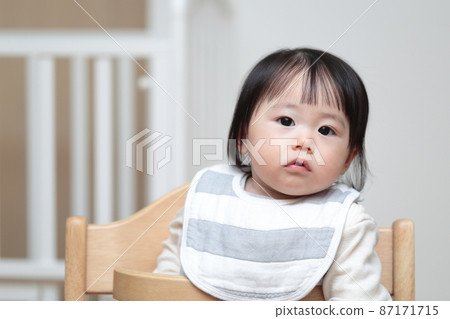 10 month old baby sitting in a baby chair Stock Photo 87171715