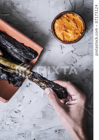 man about to eat calcots, catalan sweet onions man about to eat calcots, catalan sweet onions 87173124