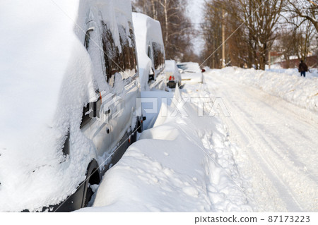 close-up view on snow-covered vehicles at sunny winter morning 87173223
