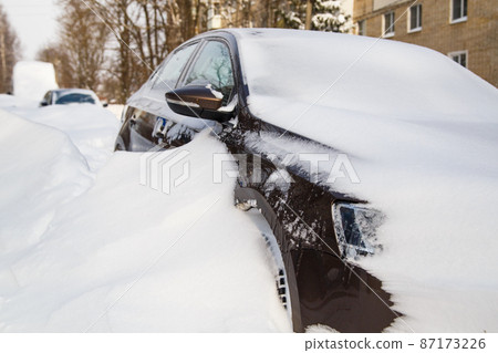 close-up view on snow-covered car at sunny winter morning 87173226
