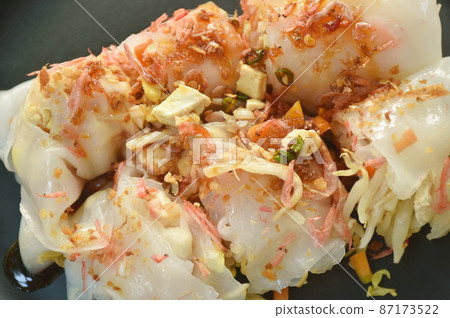 roll steamed large rice noodles stuffed slice fried tofu and chop pork dressing dry shrimp dipping with black sweet soy sauce on plate 87173522