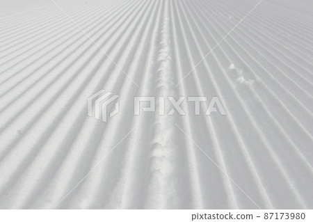 滑雪場菅平高原滑雪場在雪被壓縮的早晨的第一個斜坡上。這是一個包裝精美的冬季景觀。 滑雪場菅平高原滑雪場在雪被壓縮的早晨的第一個斜坡上。這是一個包裝精美的冬季景觀。 87173980