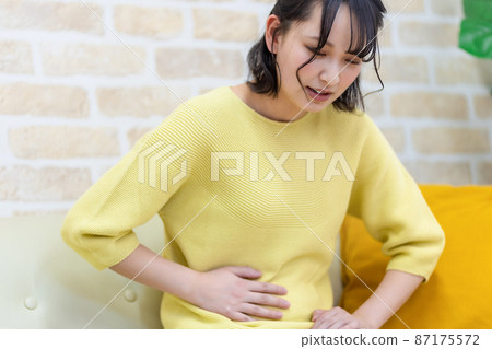 Negative image of a woman who holds her stomach and suffers 87175572