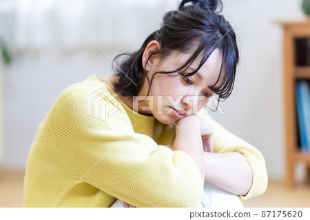 一個女人抱著膝蓋蹲下的負面形象 87175620