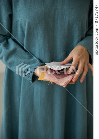 Woman holding prices of colourful linen tissue examples. 87175747