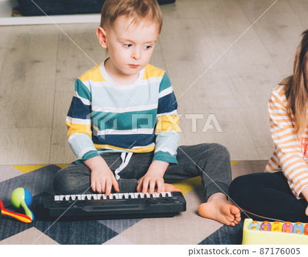 Child at home learning to play the piano. Leisure and education at home 87176005