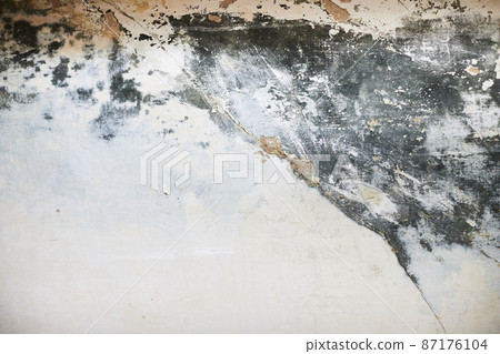 The texture of the concrete wall with partially washed away plaster, water damage and mold. Front view. 87176104