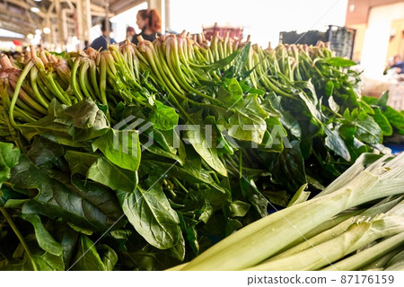Fresh green spinach for sale at vegetable market, close up. Boxes full of spinach in shop. Spinach 87176159
