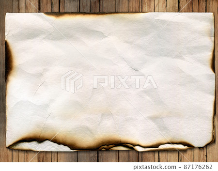 Old burned crumpled sheet of paper on wooden background. Old burned crumpled sheet of paper on wooden background. 87176262