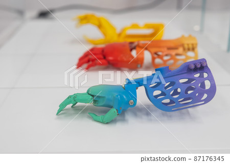 Samples of multi-colored children's prosthetic hands made of 3D plastic. 87176345