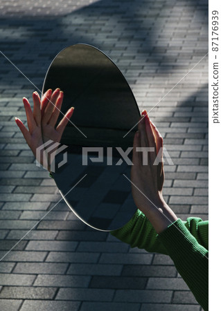 Woman's hand with a mirror Woman's hand with a mirror 87176939