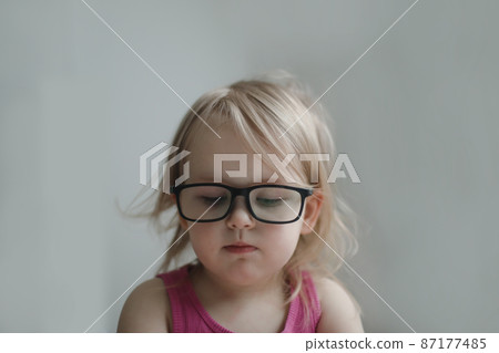 portrait of a little funny girl in eyeglasses. portrait of a little funny girl in eyeglasses. 87177485