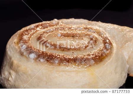 One cinnamon bun baking and rising in electric oven One cinnamon bun baking and rising in electric oven 87177733