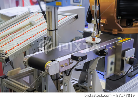 Pick and place robotic arm manipulator moving plastic detail on conveyor belt Pick and place robotic arm manipulator moving plastic detail on conveyor belt 87177819