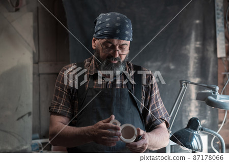 Spoon master in his workshop with wooden products and tools 87178066