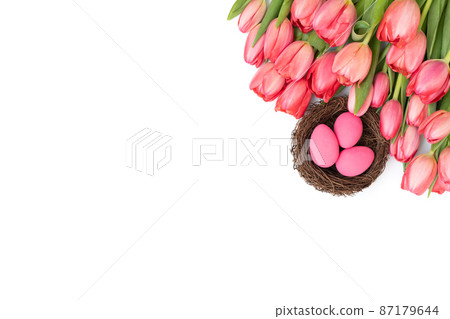 Easter border with pink tulips and eggs isolated on white background. Easter greeting card. Copy space, top view, flat lay. 87179644