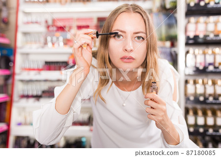 Woman testing mascara for eyes 87180085